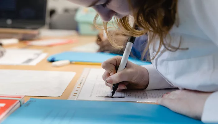 A child writes in an exercise book during a tuition session.