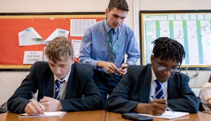 A tutor supports two pupils in a Maths session