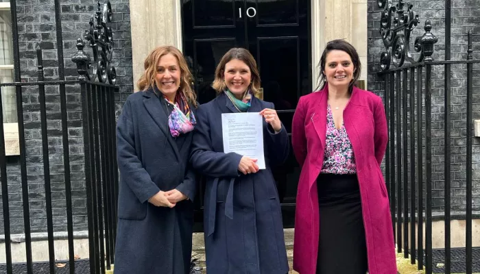 Abigail Shapiro, Susannah Hardman and Sarah Waite are pictured with the letter outside 10 Downing Street
