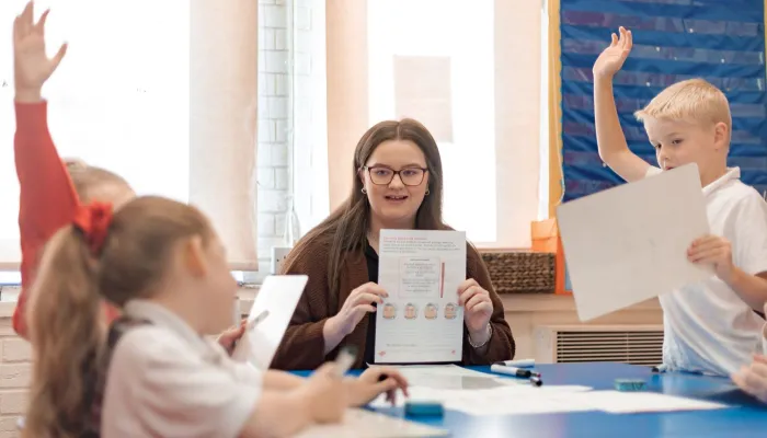 A tutor holds up a piece of paper