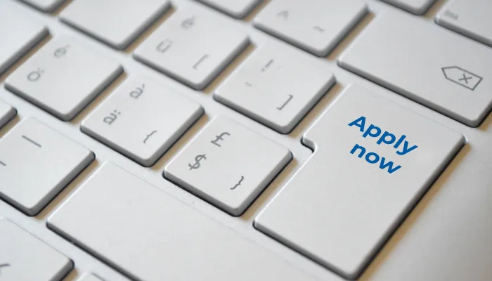 a computer keyboard with a key called apply now in blue