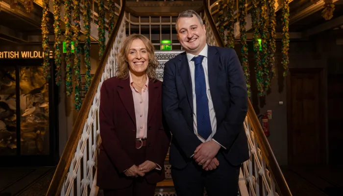 Tutor Trust Co-founder Abigail Shapiro and CEO Ed Marsh stand at the foot of a flight of stairs in Manchester Museum.