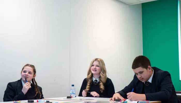 Three secondary pupils engage with tutoring