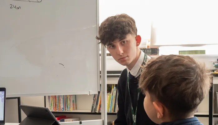 A male tutor deliver maths education for a primary aged student