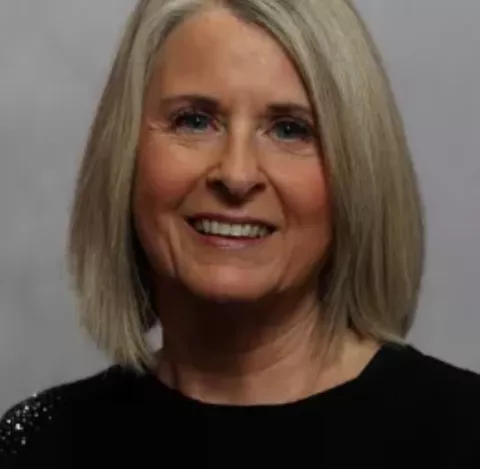 Joanne Meredith, Director of Tutoring Plus, enjoys being part of a team that makes such a difference to young people's lives. Jo has shoulder length blonde hair and is wearing a black jumper. She is smiling at the camera. 