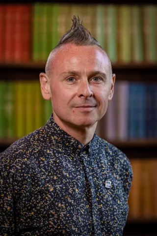 Robbie is focused on transforming the digital future of Tutor Trust, so that we can better serve our pupils and school partners, and make it easier for them to collaborate with us. Robbie is standing in front of a bookcase. He is wearing a dark shirt.