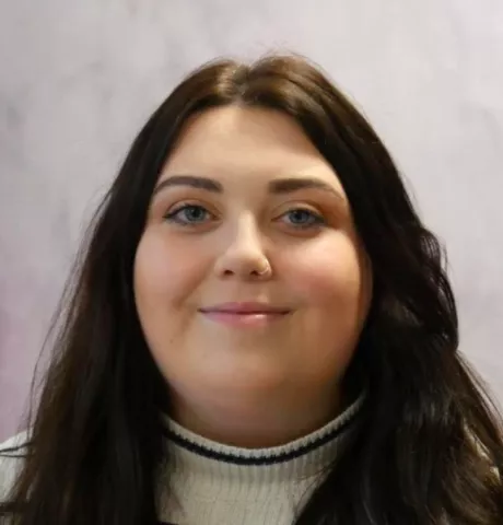Keira is passionate about interrogating our data and finding out how we can continue to improve. Keira has long brown hair and is wearing a khaki coloured top.