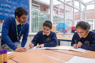 A tutor supports two young pupils