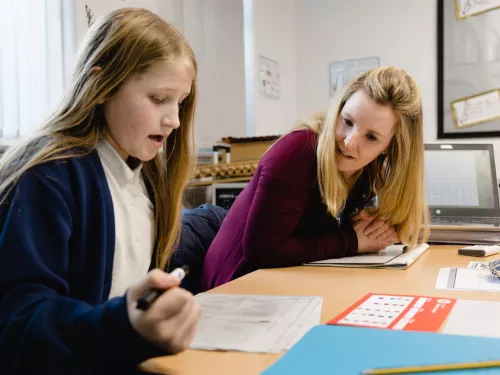 A tutor encourages a young pupil in a session.