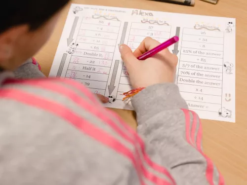 A pupils works on an activity in an exercise book