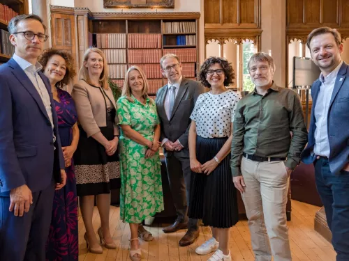 Trustees are photographed in front of a bookcase at the Tutor Trust Summer Reception in June 2023