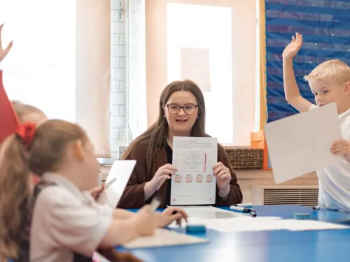 A tutor holds up a piece of paper