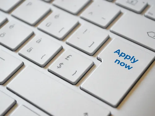 a computer keyboard with a key called apply now in blue