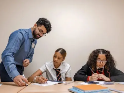 a male tutor with a beard and glasses with two year 9 girls