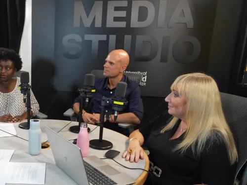 University of Salford staff sit in a recording studio to film a podcast episode
