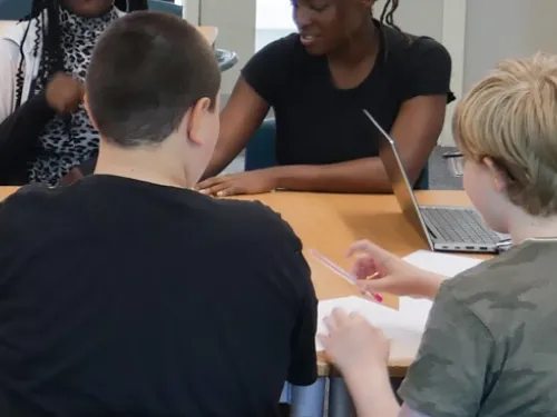 the back of two students heads, working on a school task