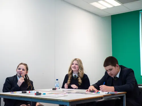 Three secondary pupils engage with tutoring