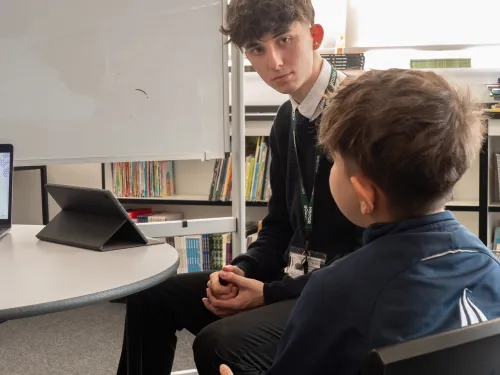 A male tutor deliver maths education for a primary aged student
