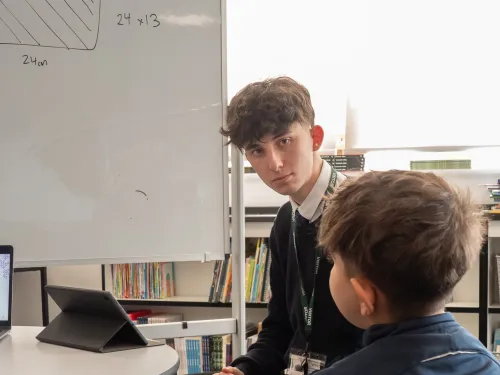 A male tutor deliver maths education for a primary aged student