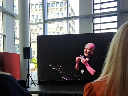 Man appears on a screen giving a speech.